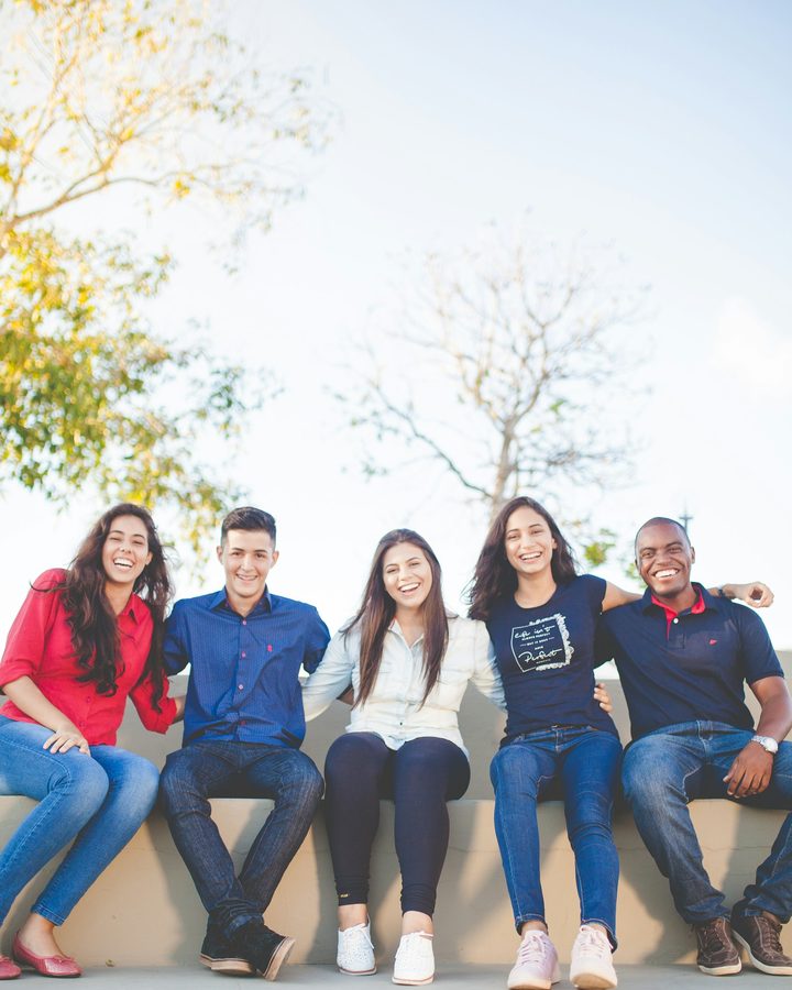 Five friends sitting together and smiling