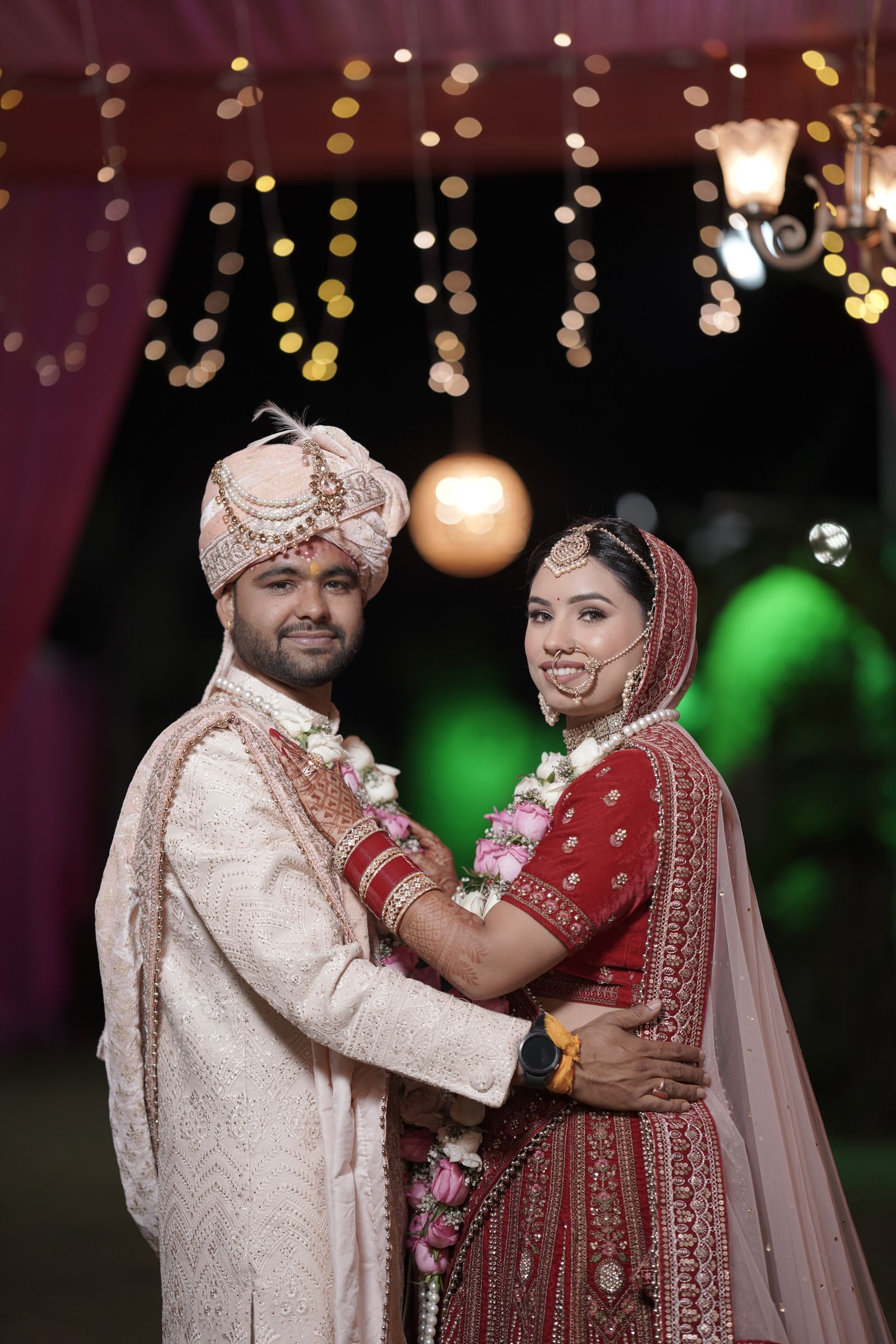 Indian bride and groom in traditional attire at their evening wedding ceremony